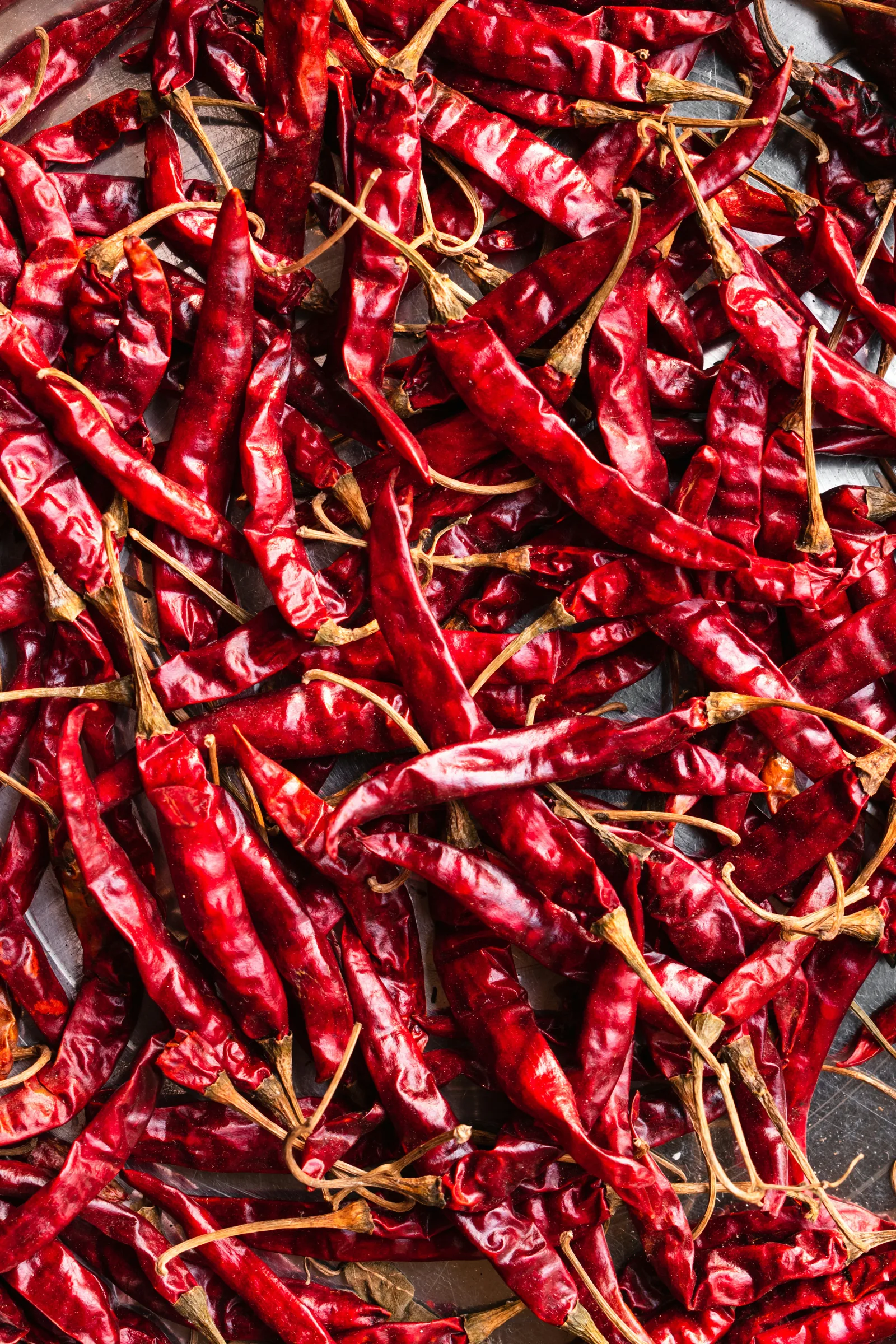 Dried red chillies spread out, representing the traditional sun-drying methods behind Ayuryogya's sourcing