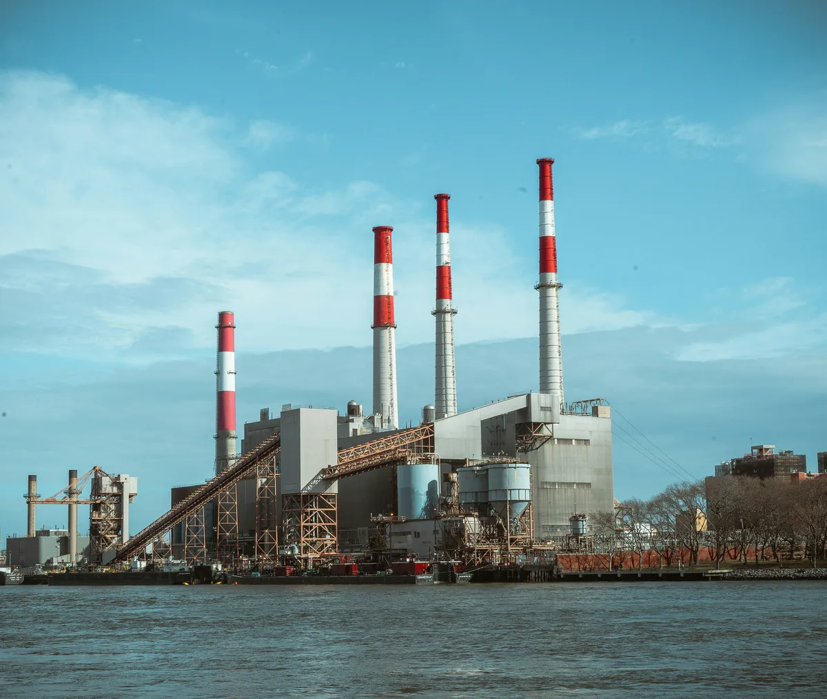 Exterior view of an industrial manufacturing facility with tall chimneys